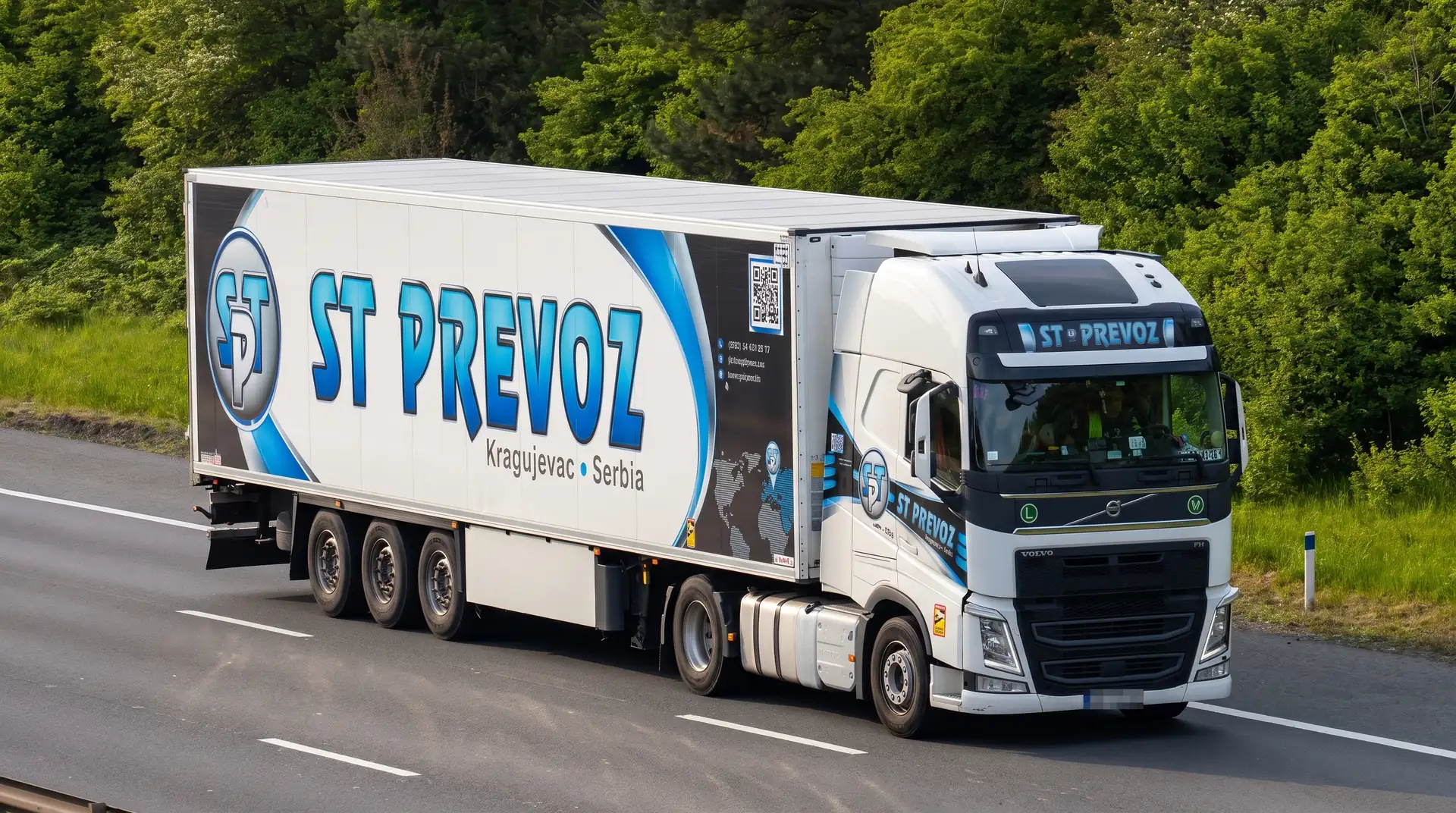 Tegljač Volvo FH sa hladnjačom ST PREVOZ na autoputu, između drveća